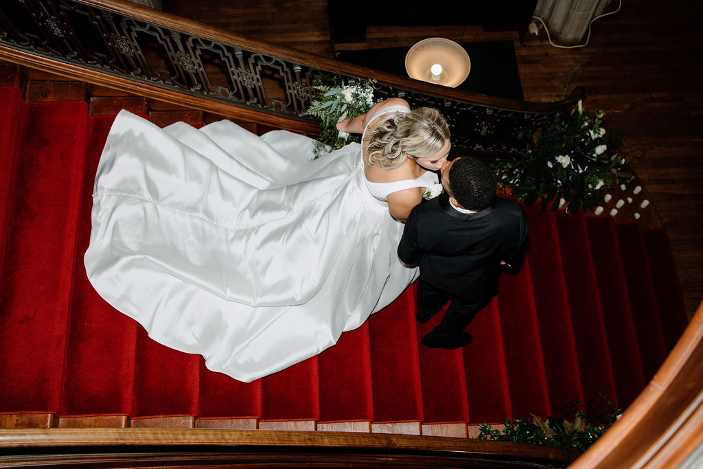 A bride and groom descending a grand staircase at Callanwolde Fine Arts during their day of coordination wedding