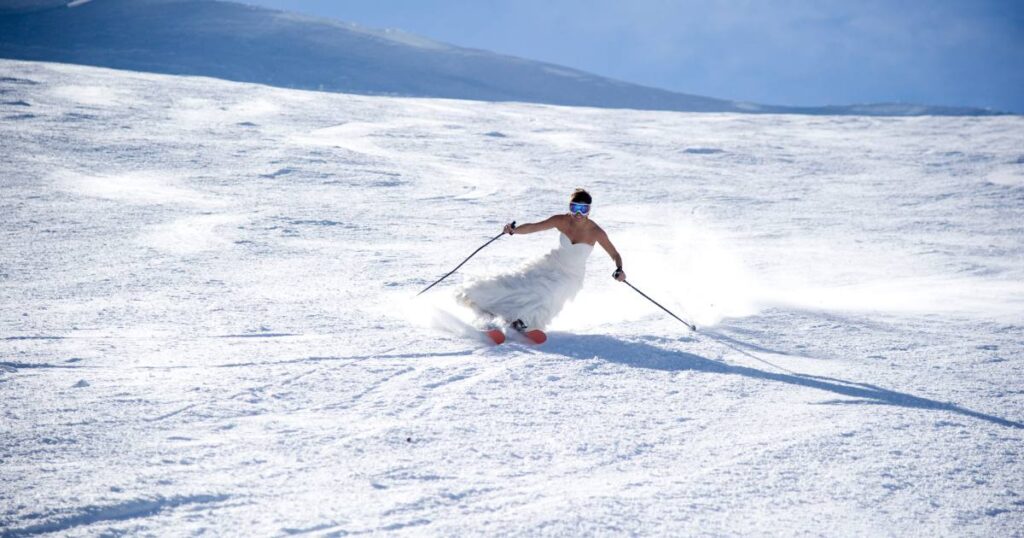 This is a creative wedding photo idea of a bride skiing